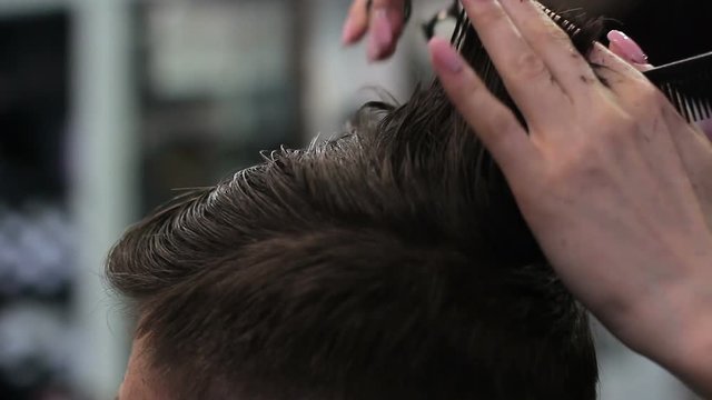 Barber Cuts the Hair in the Barbershop. Close-up