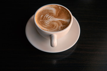 Cup of coffee over the black tabletop background