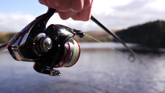 Fisherman reeling in a fish, close up of reel