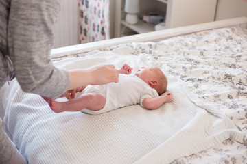 Young mother changing her newborn baby girl.