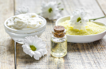 Obraz na płótnie Canvas close up body care camomile cosmetic products on wooden desk background