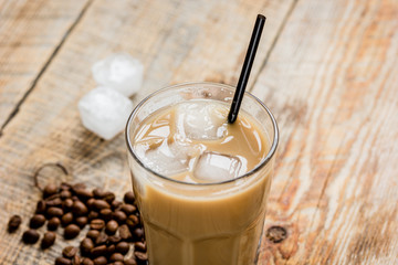 coffee ice cubes and beans with latte on wooden desk background