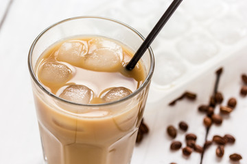 cold coffee glass with ice cubes on white table background