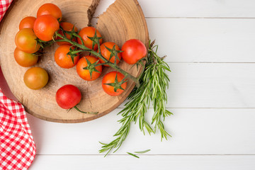 Organic cherry tomatoes with rosemary on rustic wooden table