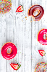 sweet colorful donuts with topping on wooden desk background top view mock-up