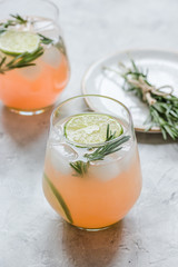 vegetable smoothie with lime and rosemary in glass on stone table background