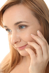 Senior woman applying anti-aging cream on face, closeup