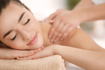Fototapeta na wymiar Beautiful young woman receiving massage in spa salon, closeup