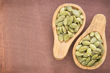 Pumpkin seeds on the wooden background