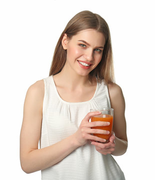 Beautiful young woman with glass of fresh juice on light background