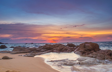 blue sky beach and waves hitting coast at  sunset 