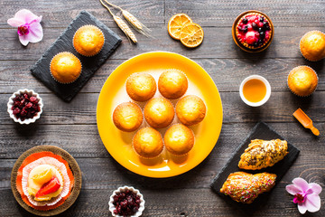 Delicious homemade muffins with yogurt, on a wooden background with space for text.