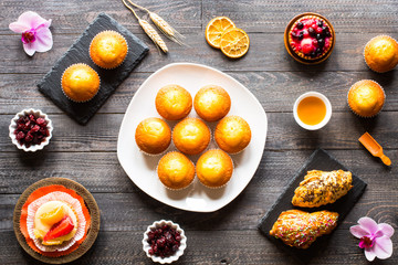 Delicious homemade muffins with yogurt, on a wooden background with space for text.