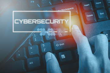 Technology concept showing CYBERSECURITY while the finger pressed button on the keyboard