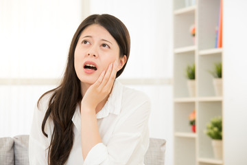 Toothache young woman touching her cheek