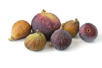 Several varieties of ripe common figs on white background.