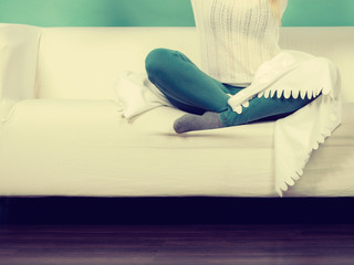 Woman wearing jeans and jumper sitting on sofa