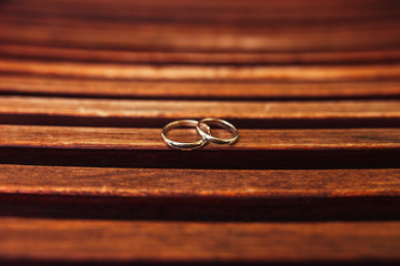 Gold wedding rings on a wooden background