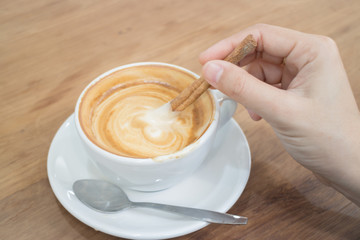 Hand On Hot Cup Of Coffee Latte