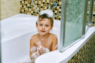 the boy takes a bath . Hygiene and body care