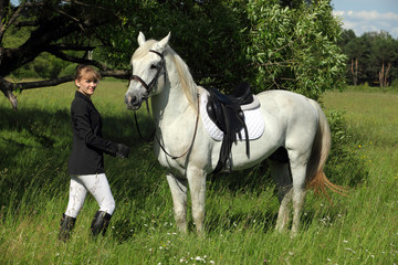 White purebred horse and blonde woman portrait, English riding clothes 