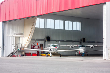 Small aircraft in open hangar © Dushlik