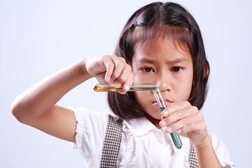 Little girl holding a test tube with liquid Scientist chemistry and science education concept
