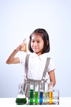 Little girl holding a test tube with liquid Scientist chemistry and science education concept