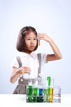 Little girl holding a test tube with liquid Scientist chemistry and science education concept