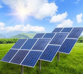 Solar panels on green grass with blue sky