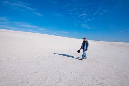 Man traveler, tired after a hard day, walks through the desert.