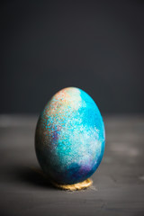 Colored easter egg on the dark background. Shallow depth of field.
