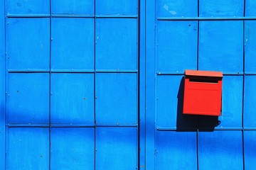 Red mailbox on the blue door. Red postbox on blue background.