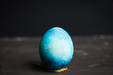 Colored easter egg on the dark background. Shallow depth of field.