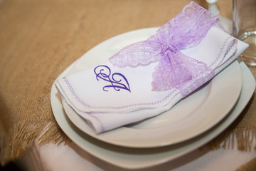 Fototapeta na wymiar Napkin decorated with purple lace on the table for wedding celebrations. Handmade. Close-up.