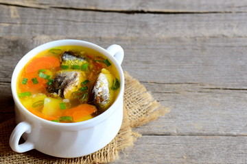 Hearty and slow fish soup. Homemade fish soup with vegetables in a bowl. Vintage wooden background with copy space for text. Closeup 
