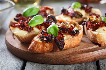 Appetizer bruschetta with sun-dried tomatoes, olives and mozarella.