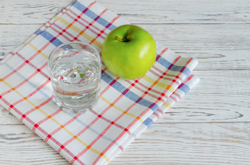 Glass of water with green apple
