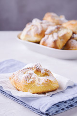 Homemade hungarian Cheese Puff Pastry Parcels. Cottage cheese puffs (buns, patties, cheesecakes) with raisins on light grey concrete background. Selective focus 