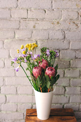 Flowers in vase. Craspedia, freesia and protea flowers. Flower market
