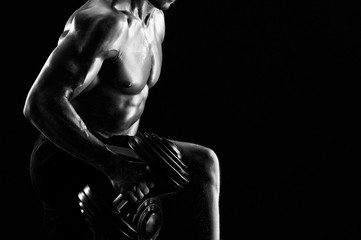 Fototapeta na wymiar Cropped monochrome close up of a ripped athletic man exercising with dumbbells copyspace fitness fit toned strong powerful muscular muscles brutal brutality masculinity sportive determination.