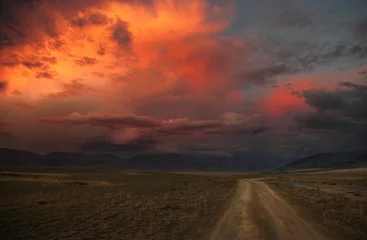 Papier peint photo autocollant rond Sécheresse Chemin de la route sur un plateau de montagne sauvage du désert à l& 39 arrière-plan des collines sous un ciel coloré de coucher de soleil spectaculaire avec des nuages rouges roses violets illuminés Montagnes de l& 39 Altaï Kurai Sibérie Russie