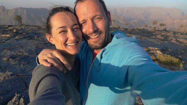 Happy couple recording video, taking selfie in the mountains, super slow motion 240fps
