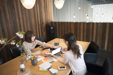 Women are meeting at the tablet while watching