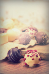 Selection of delicious chocolates on a rustic background