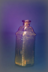 Old colourful bottles against a dark background