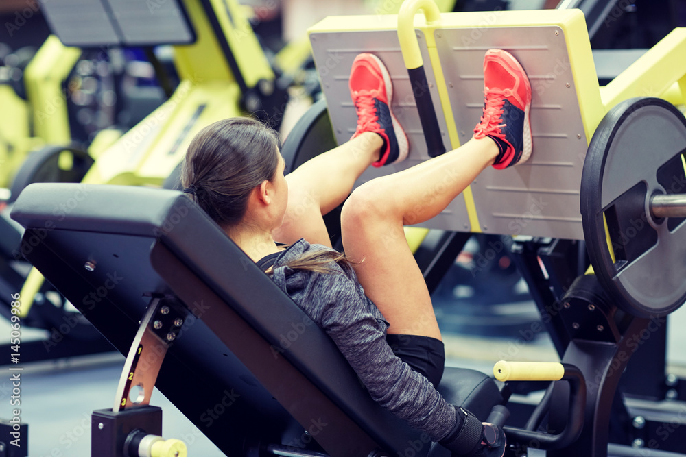 Canvas Prints woman flexing muscles on leg press machine in gym