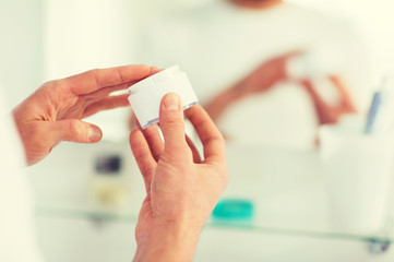 close up of happy young man with cream at bathroom