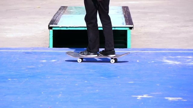 A man playing skateboard trick on concrete floor in slow motion