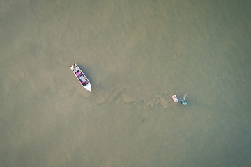 Fisherman with small boat in the sea. Aerial view from flying drone